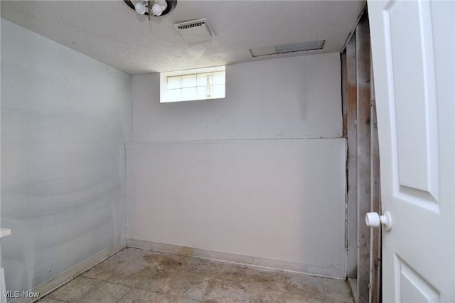 basement featuring a textured ceiling