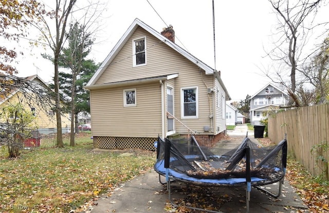 rear view of house featuring a trampoline