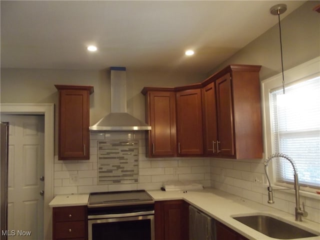 kitchen with a wealth of natural light, sink, wall chimney exhaust hood, and stainless steel range with electric stovetop