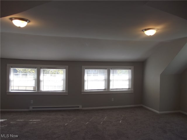 carpeted spare room featuring lofted ceiling, a wealth of natural light, and a baseboard radiator