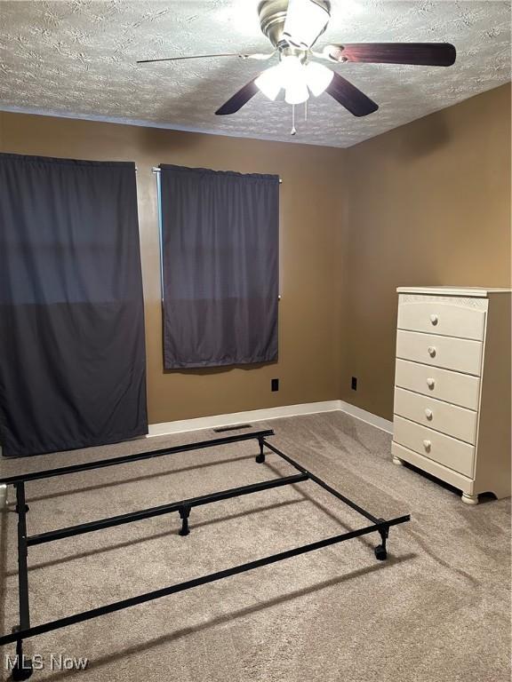 unfurnished bedroom with carpet flooring, a textured ceiling, and ceiling fan