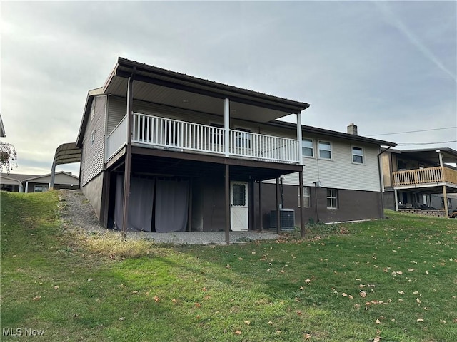 rear view of house with a yard, a balcony, and central AC