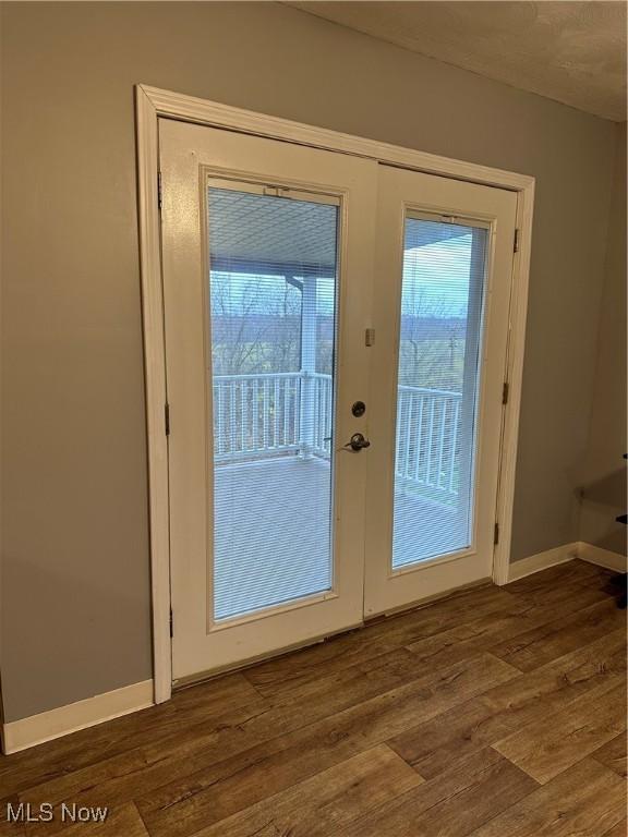 entryway with dark wood-type flooring and french doors