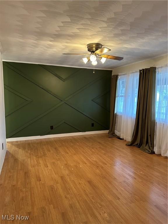 unfurnished room with ceiling fan and hardwood / wood-style flooring