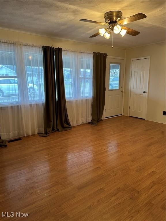 spare room featuring hardwood / wood-style flooring, ceiling fan, and plenty of natural light