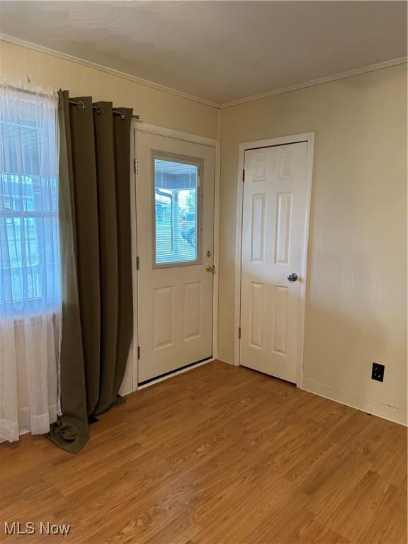 foyer featuring light wood-type flooring and crown molding