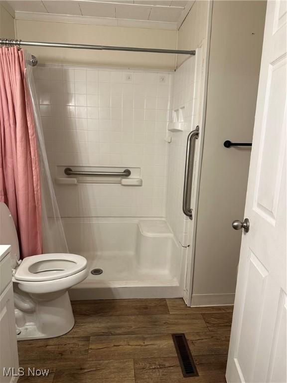 bathroom with crown molding, toilet, hardwood / wood-style flooring, vanity, and a shower with shower curtain