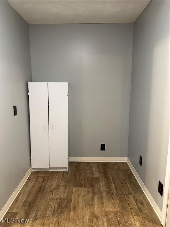 laundry area with dark hardwood / wood-style flooring