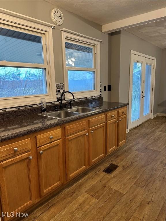 kitchen featuring french doors, dark wood-type flooring, and sink