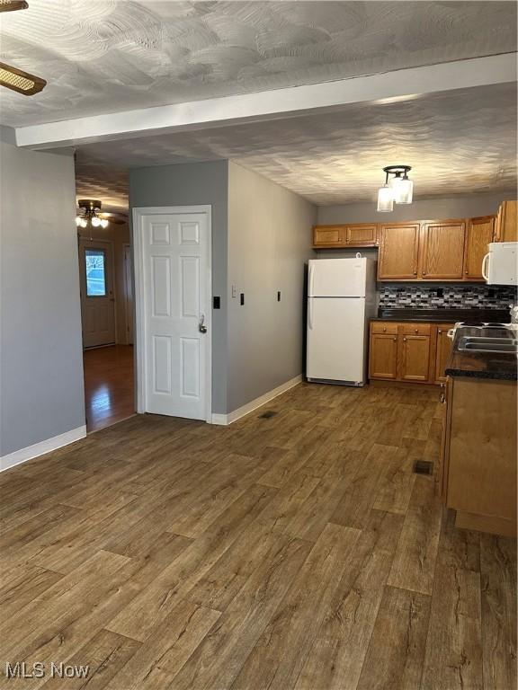 kitchen featuring ceiling fan, sink, dark hardwood / wood-style floors, backsplash, and white appliances