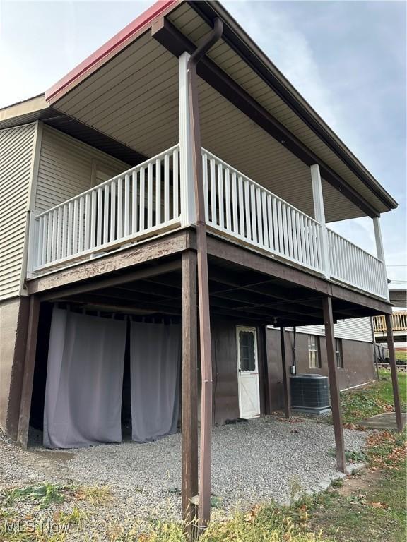 view of side of property featuring a balcony and central air condition unit