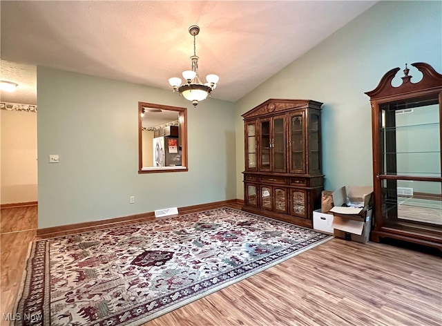 interior space with hardwood / wood-style floors and an inviting chandelier