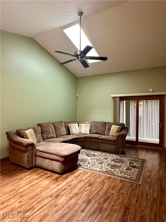 living room with hardwood / wood-style flooring, ceiling fan, and lofted ceiling