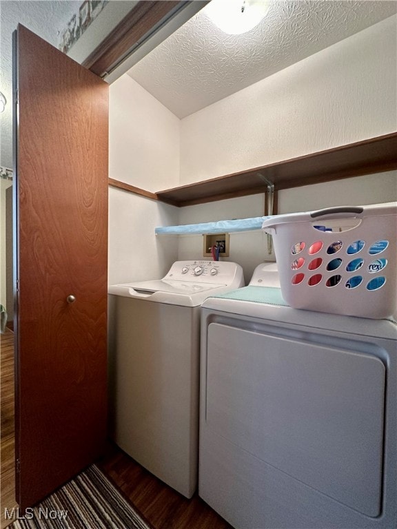 washroom featuring a textured ceiling, dark hardwood / wood-style flooring, and separate washer and dryer