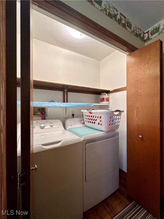 clothes washing area featuring a textured ceiling, separate washer and dryer, and dark wood-type flooring