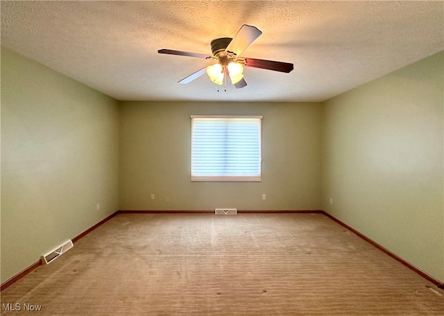 carpeted spare room with a textured ceiling and ceiling fan