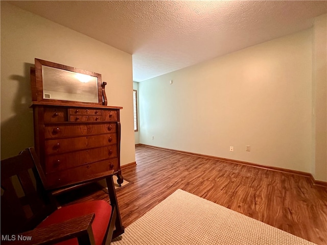 bedroom with a textured ceiling and hardwood / wood-style flooring