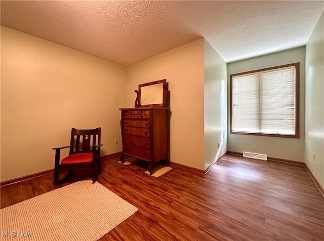 unfurnished room featuring hardwood / wood-style floors and a textured ceiling