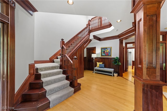 staircase with hardwood / wood-style floors and ornamental molding