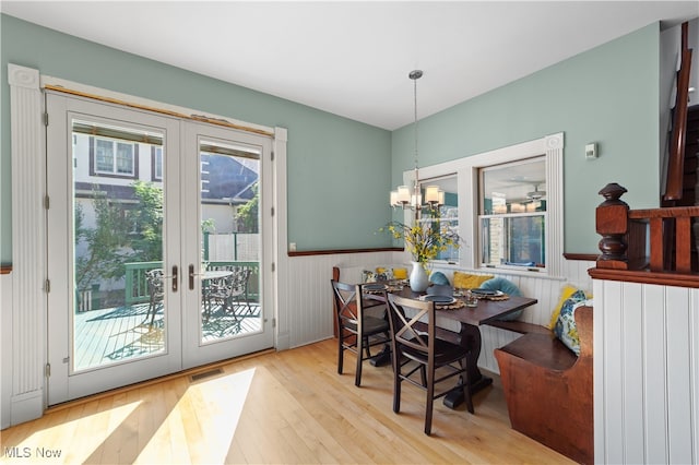 dining space with a notable chandelier, light hardwood / wood-style floors, and french doors