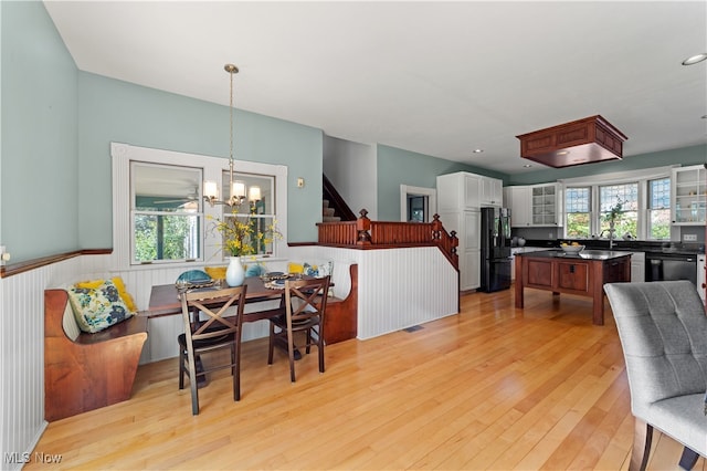 dining area featuring a notable chandelier, light wood-type flooring, and sink