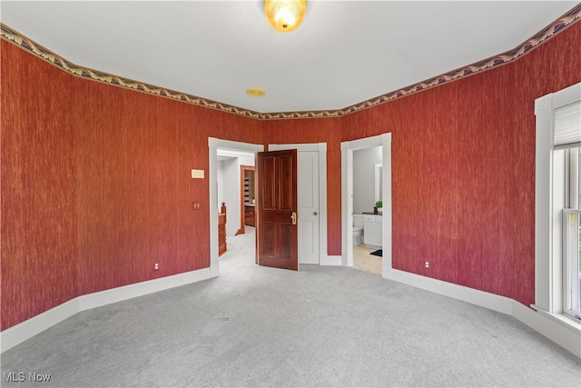 unfurnished bedroom featuring carpet and ensuite bathroom