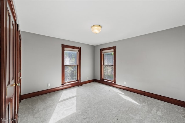 unfurnished room featuring light carpet