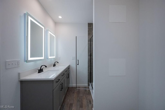 bathroom with vanity, a shower with shower door, and hardwood / wood-style flooring