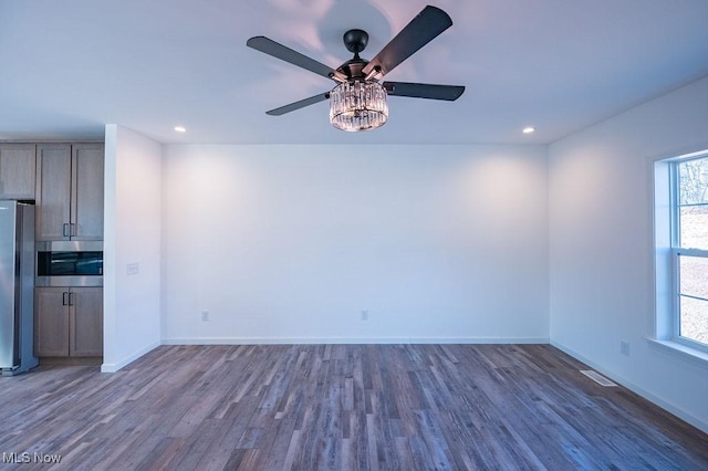 interior space featuring ceiling fan, a healthy amount of sunlight, and dark hardwood / wood-style flooring