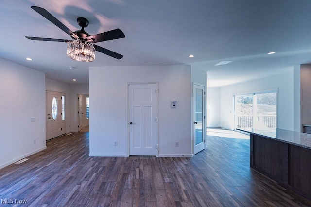 unfurnished living room featuring ceiling fan and dark hardwood / wood-style floors