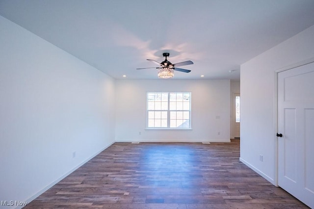 spare room featuring ceiling fan and dark wood-type flooring