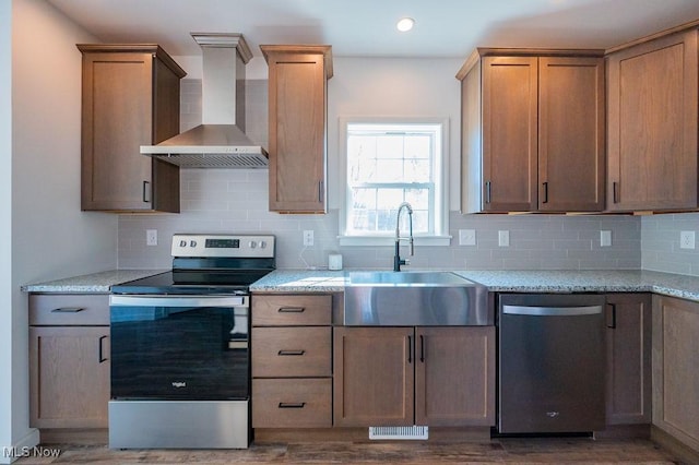 kitchen featuring wall chimney exhaust hood, dark hardwood / wood-style floors, sink, and appliances with stainless steel finishes