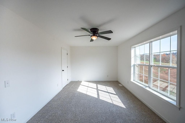 carpeted empty room featuring ceiling fan