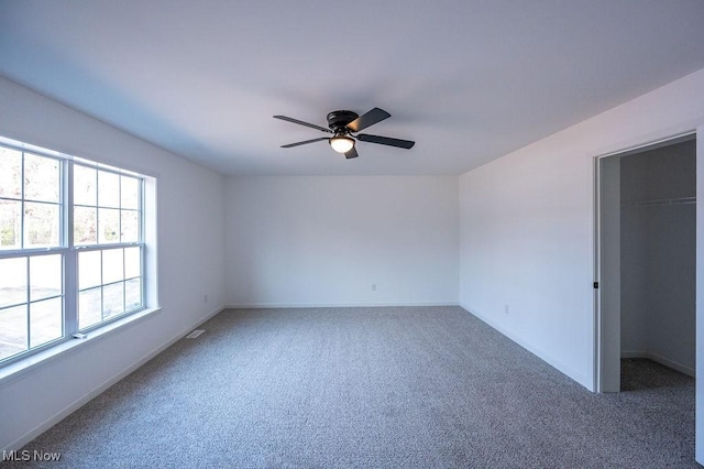 spare room with ceiling fan and carpet