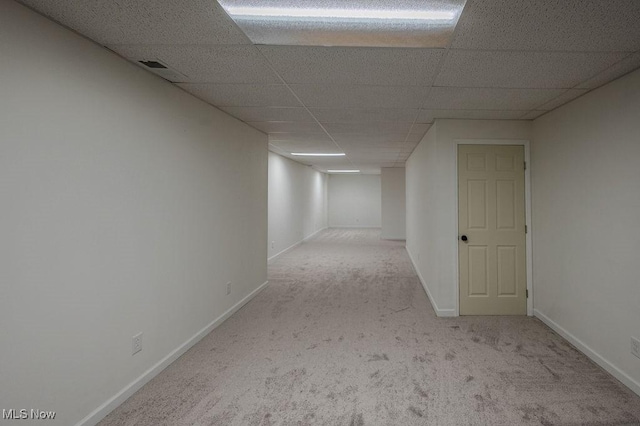 interior space featuring light carpet and a paneled ceiling