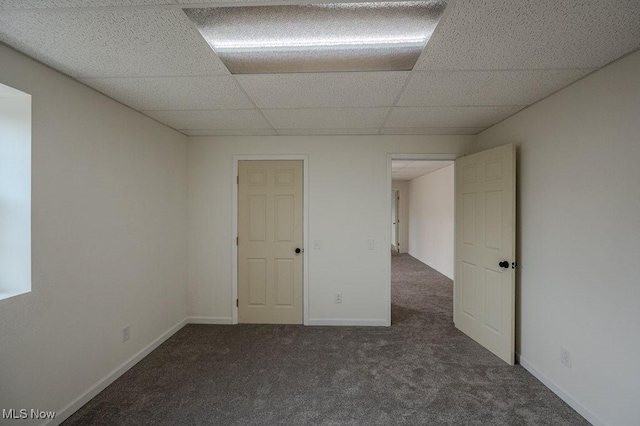 carpeted spare room with a paneled ceiling