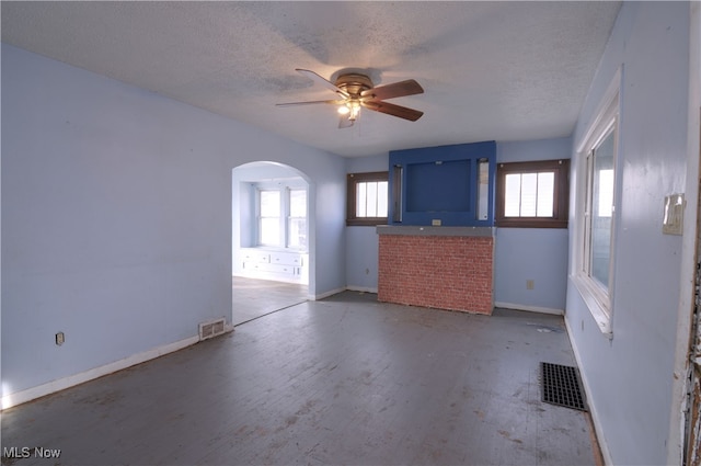 unfurnished living room featuring wood-type flooring, a textured ceiling, and ceiling fan