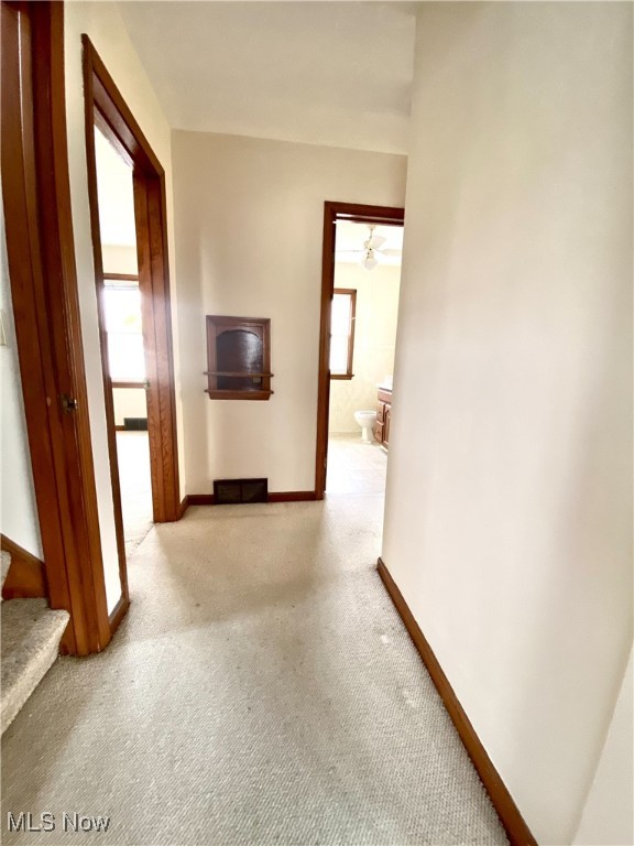 hallway featuring light colored carpet