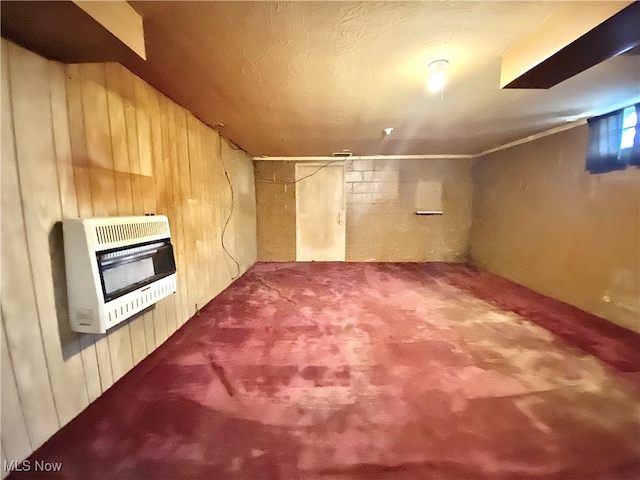 basement featuring heating unit, carpet, and wood walls