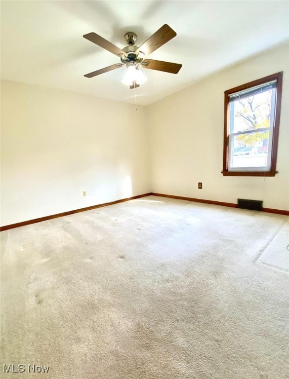 spare room featuring ceiling fan and light colored carpet