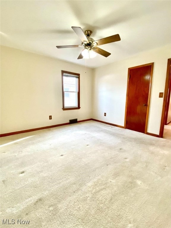 spare room with light carpet and ceiling fan