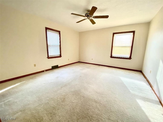 spare room featuring ceiling fan and carpet floors