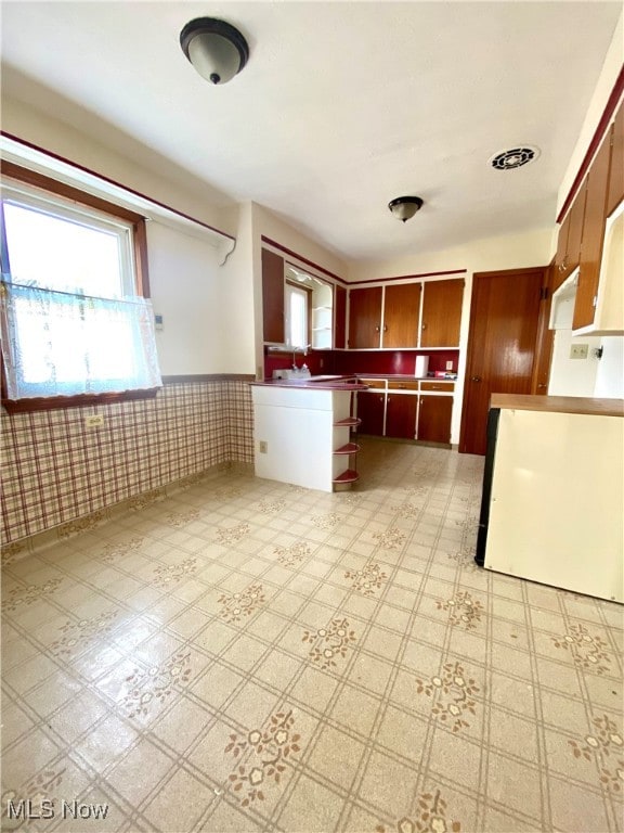 kitchen featuring stove and tile walls