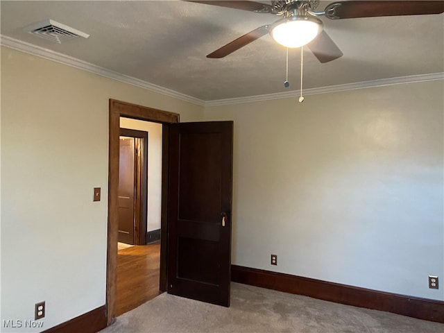 unfurnished bedroom with ceiling fan, carpet floors, and ornamental molding