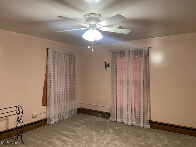 carpeted spare room featuring ceiling fan