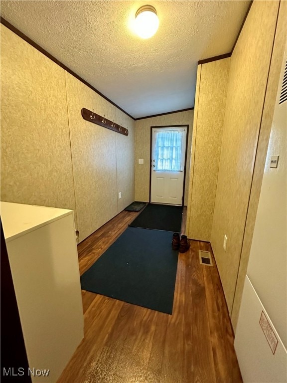 workout room featuring a textured ceiling, dark hardwood / wood-style flooring, and vaulted ceiling