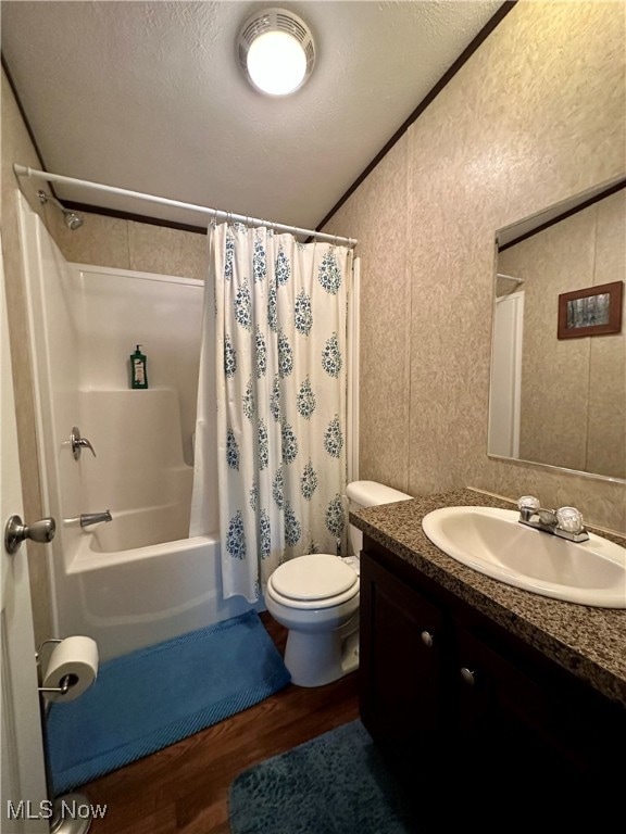 full bathroom with vanity, toilet, shower / bathtub combination with curtain, a textured ceiling, and wood-type flooring