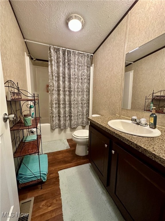 full bathroom with vanity, hardwood / wood-style floors, a textured ceiling, and shower / tub combo