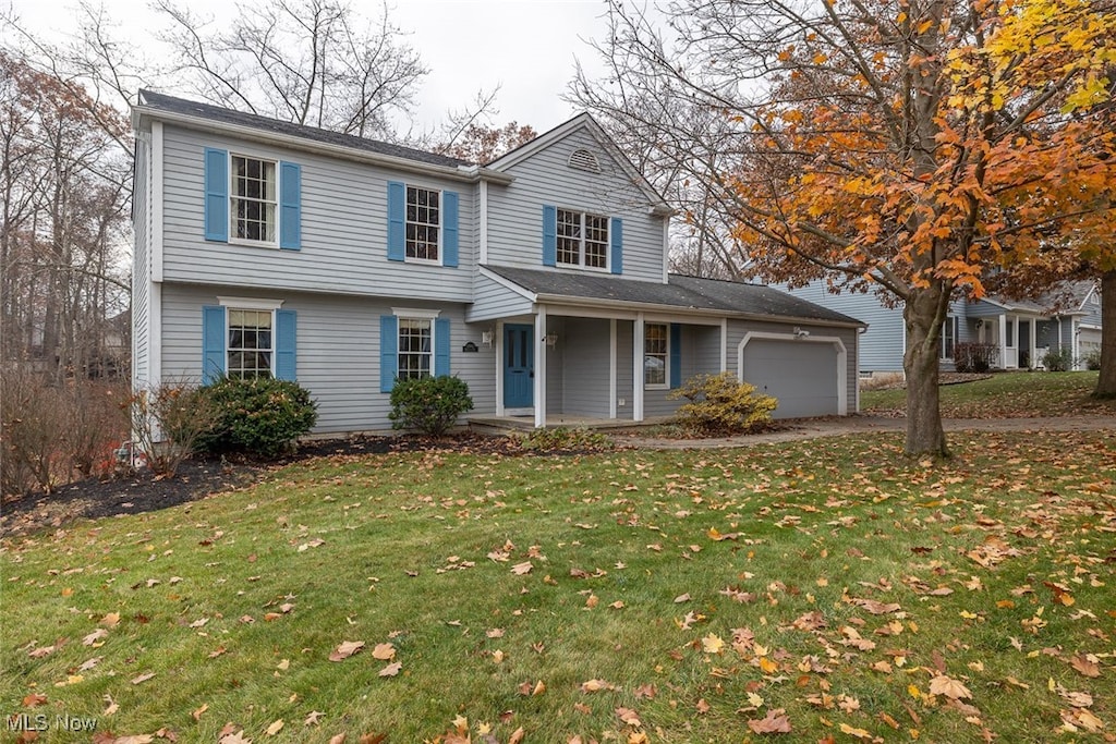 view of front facade featuring a front lawn, a porch, and a garage