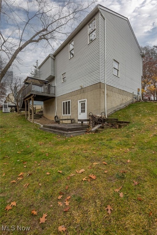 back of house with a deck and a lawn